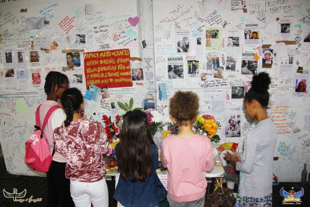 Image of children facing a wall with flowers and notes written to remember.